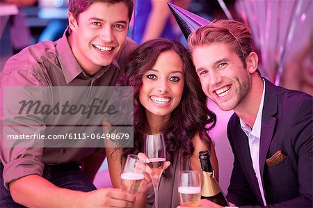 Portrait of smiling friends drinking champagne in nightclub