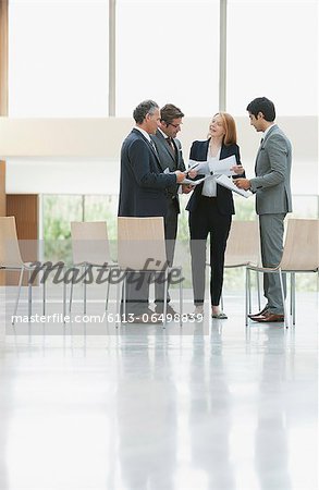 Business people reviewing paperwork in lobby