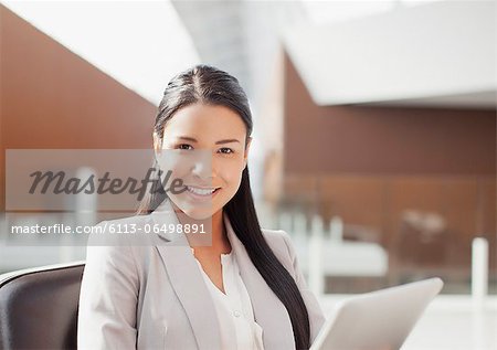 Portrait of smiling businesswoman using digital tablet in office