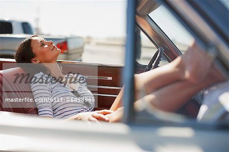 Smiling woman relaxing in convertible