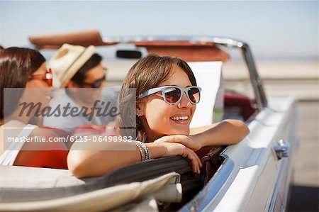 Smiling woman leaning out convertible