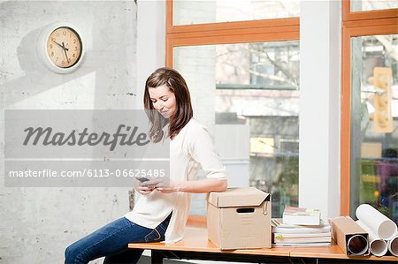 Businesswoman using cell phone in office