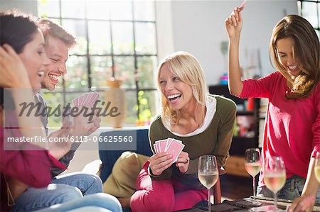 Friends playing card game in living room