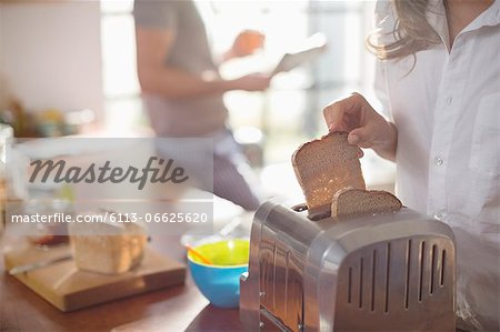 Woman Putting Bread In Toaster Stock Photo Masterfile Premium Royalty Free Code 6113