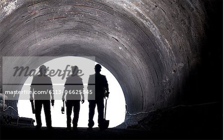 Silhouette of workers in tunnel