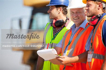 Businessman and workers talking on site