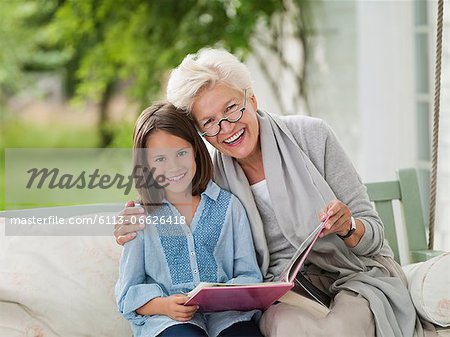 Woman and granddaughter smiling in porch swing