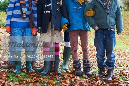 Children standing together in autumn leaves