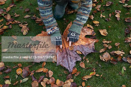 Girl playing with autumn leaves