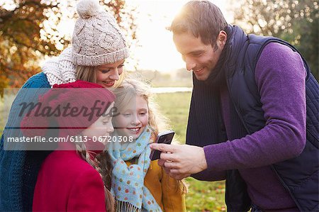 Family using cell phone together outdoors