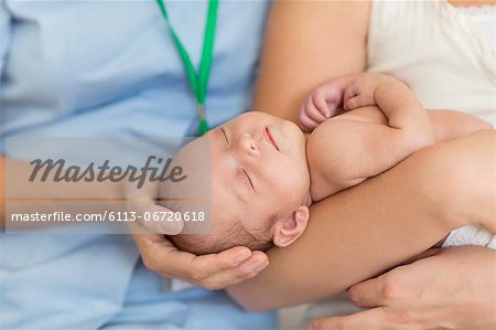 Nurse and mother cradling newborn baby