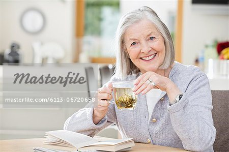 Older woman drinking tea and reading