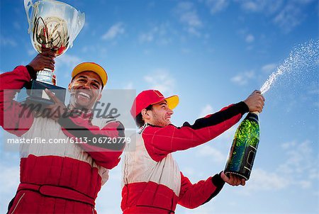 Racers holding trophy and champagne