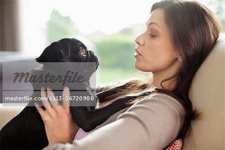 Woman relaxing with dog on sofa