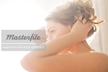 Woman playing with her hair in bedroom