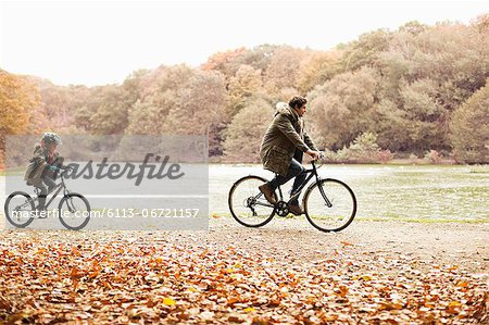 Father and son riding bicycles in park Father and son riding bicycles in park