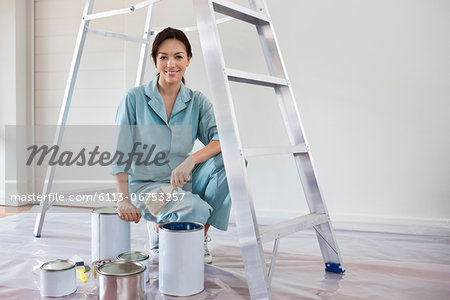 Smiling woman painting room