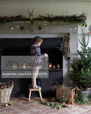 Boy decorating Christmas fireplace