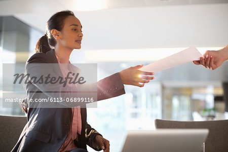 Businesswoman reaching for paperwork