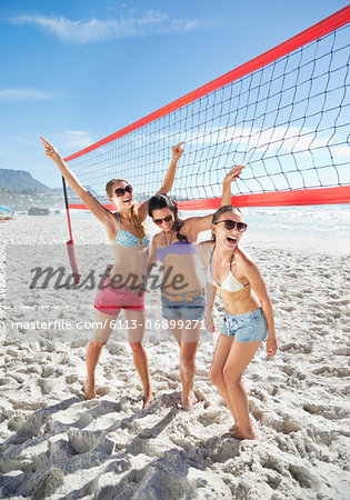 Happy friends on beach volleyball court