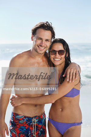 Portrait of smiling couple hugging on beach