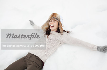 Enthusiastic woman making snow angel