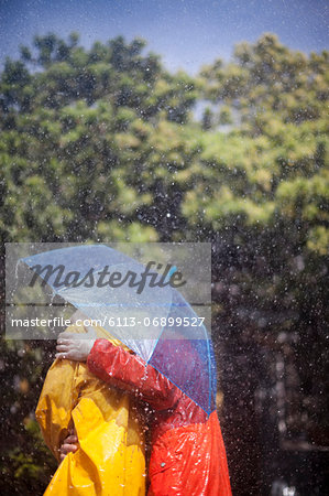 Couple hugging under umbrella in rain