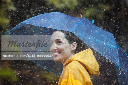 Happy woman with umbrella in rain