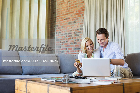 Couple shopping online on sofa