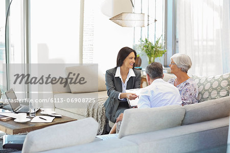 Financial advisor talking to couple on sofa Financial advisor talking to couple on sofa