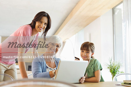 Three generations of women using laptop together Three generations of women using laptop together