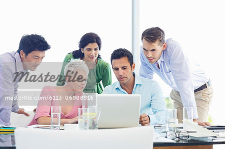 Business people using laptop in meeting