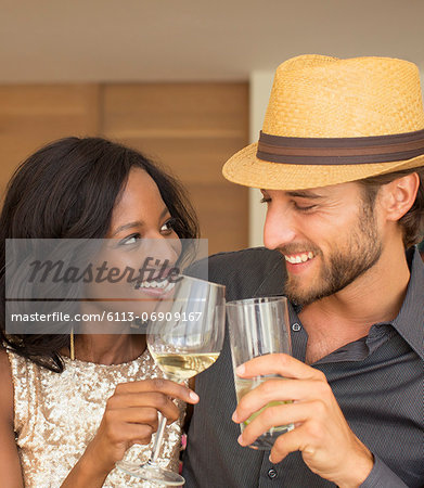 Couple toasting each other indoors