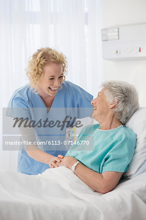 Nurse and senior patient talking in hospital room