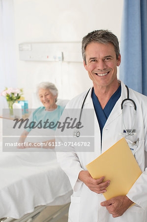 Portrait of smiling doctor with patient in background