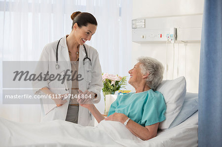 Doctor and senior patient talking in hospital room