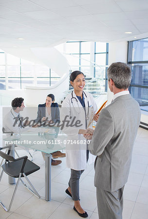 Doctor and businessman shaking hands in meeting