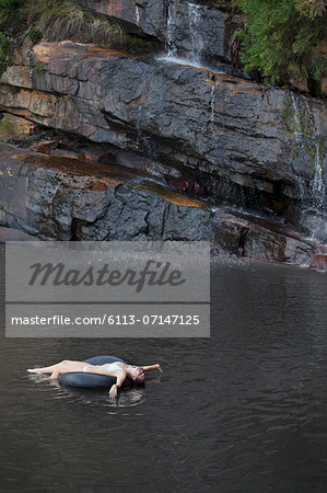 Woman floating in inner tube on river