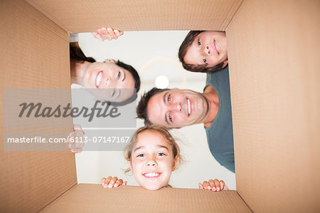 Family looking down at camera through cardboard box