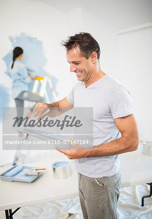 Couple painting wall blue Couple painting wall blue