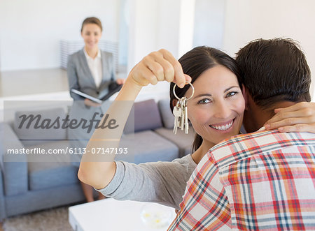 Portrait of happy couple hugging with house keys