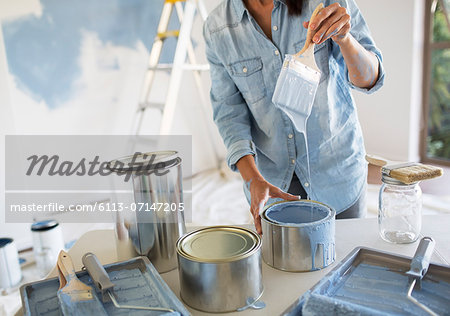 Woman holding paintbrush with blue paint