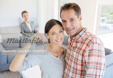 Portrait of smiling couple holding house keys Portrait of smiling couple holding house keys