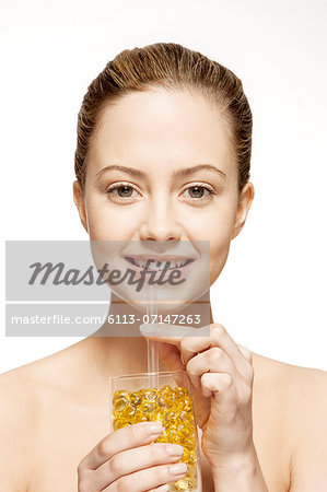 Woman drinking glass of vitamins