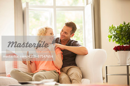Couple using digital tablet on sofa Couple using digital tablet on sofa