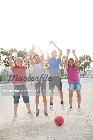 Children playing with soccer ball in sand