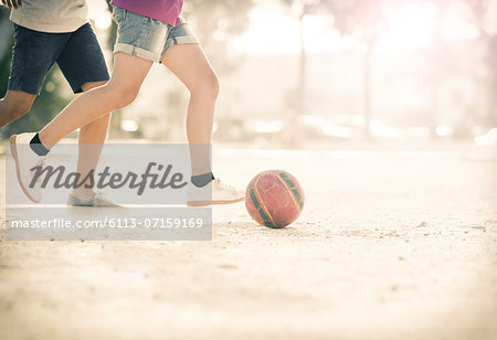 Children playing with soccer ball in sand