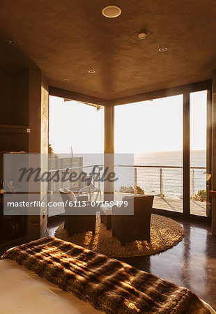 Luxury bedroom overlooking ocean at sunset
