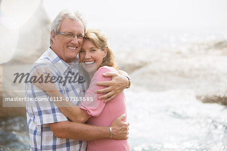 Older couple hugging on beach