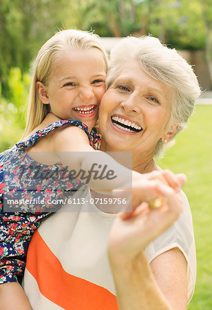 Smiling grandmother holding granddaughter